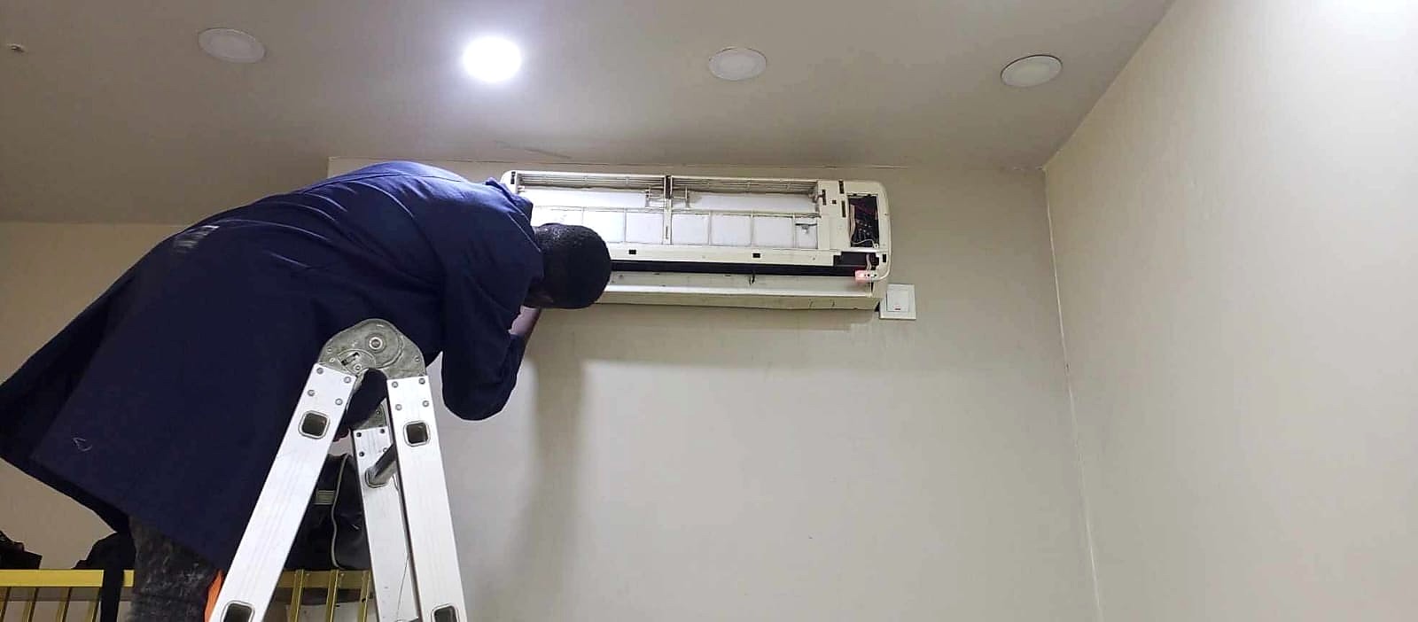 Technician servicing a wall-mounted air conditioner